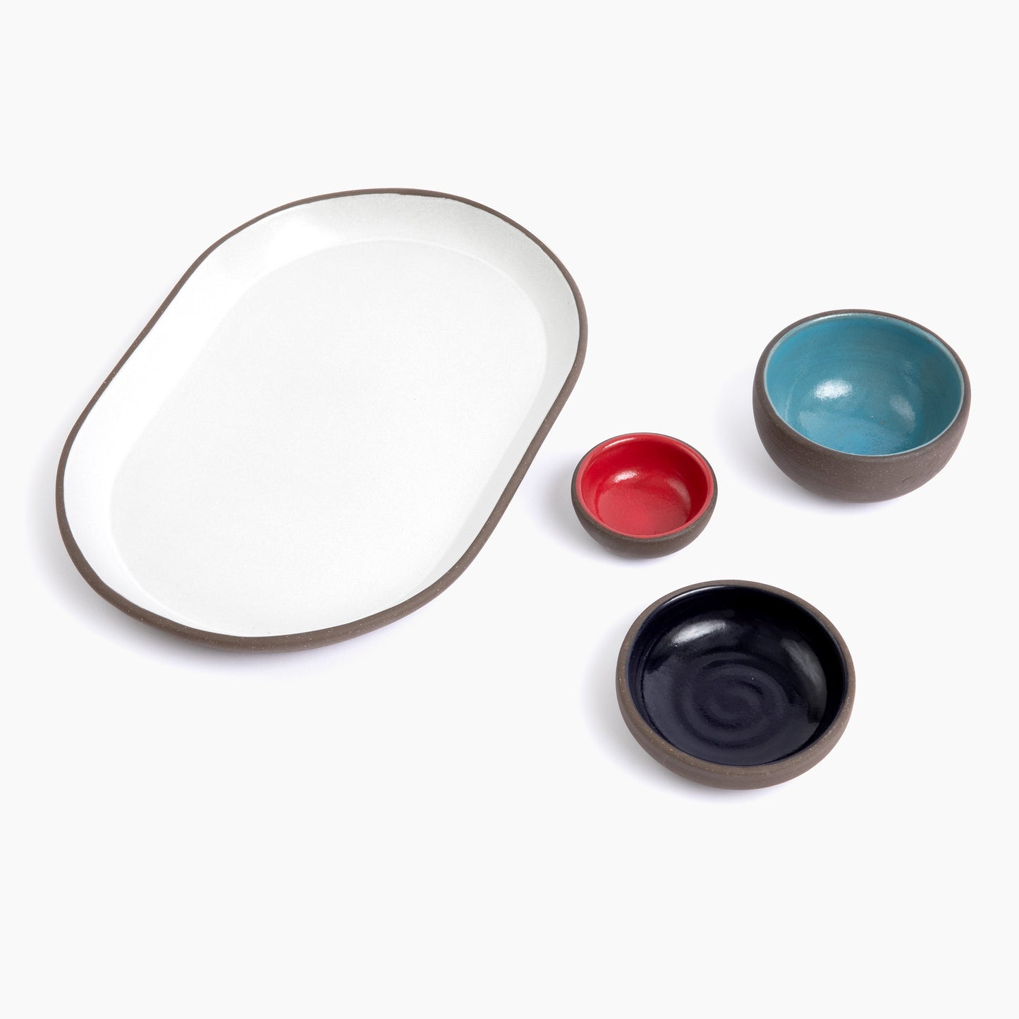 A set of four ceramic serveware pieces with a dark brown and white color scheme, including a medium oval tray, a fry bowl, a gelée bowl, and a condiment bowl.