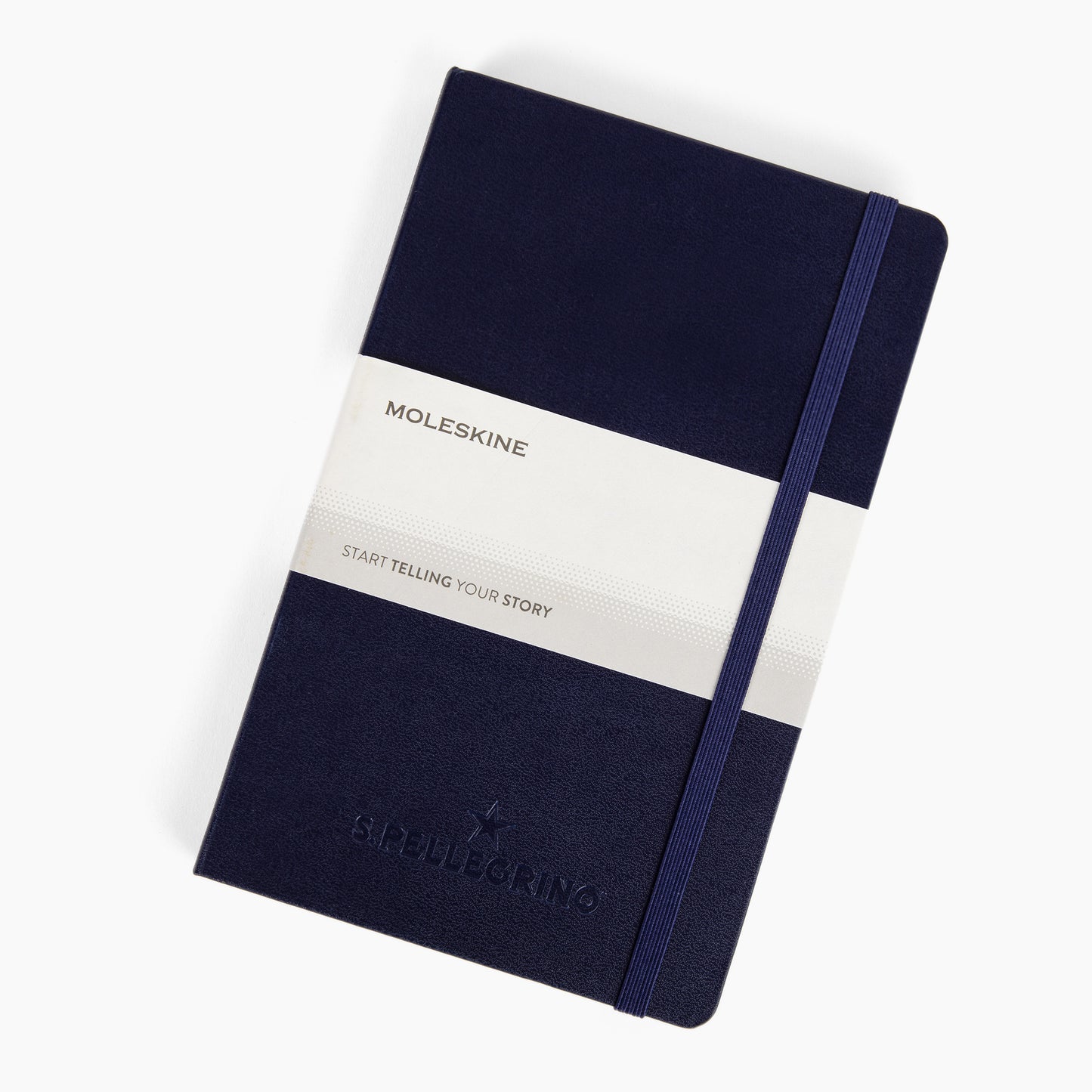 A navy blue and white striped Moleskine hard cover notebook with the brand's logo on the front cover.